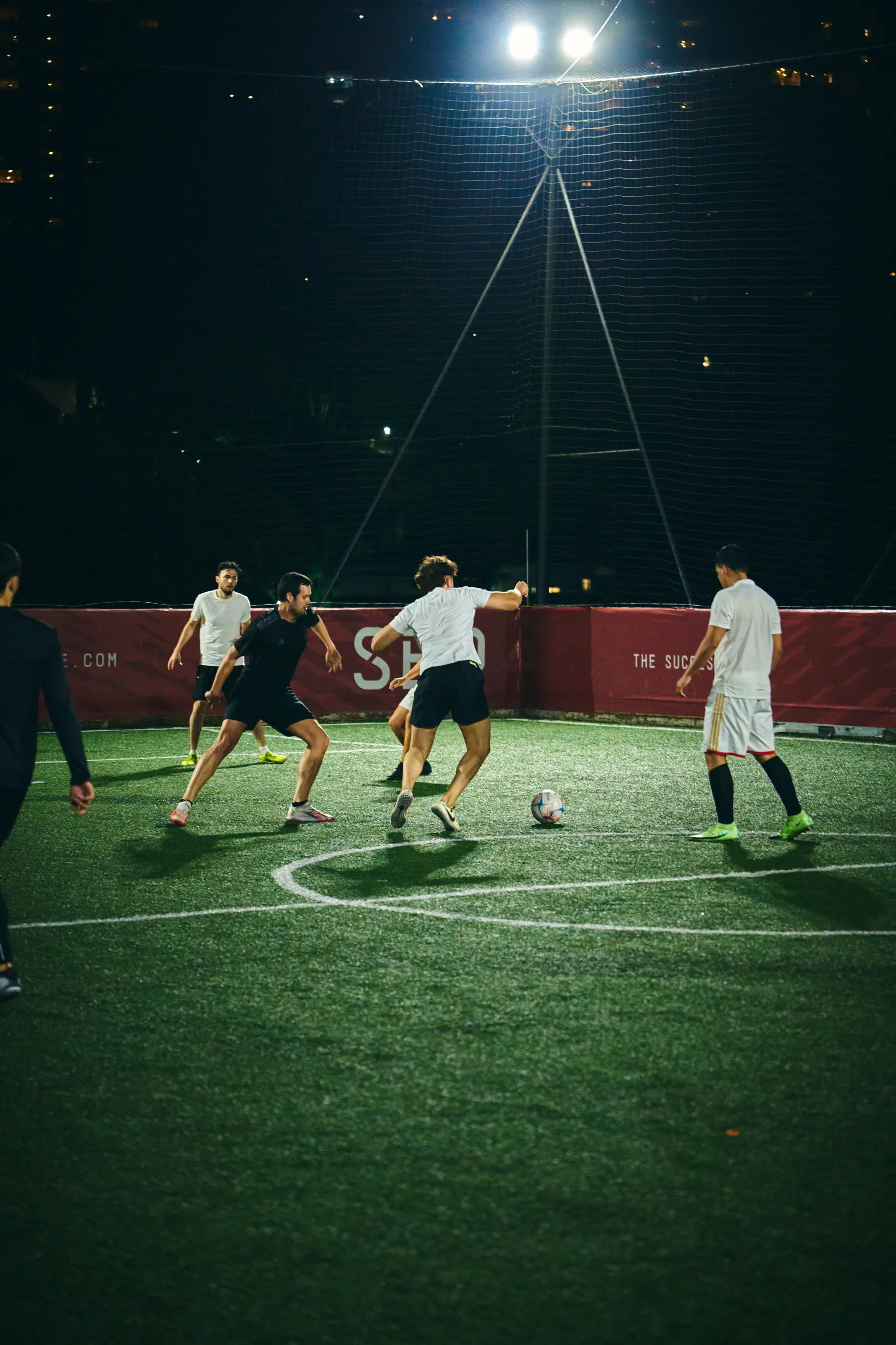Partido de fútbol nocturno en una cancha de La Jaula